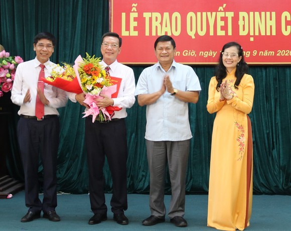 Ông Nguyễn Văn Hồng (ôm hoa) nhận quyết định mới. Ảnh: SGGP