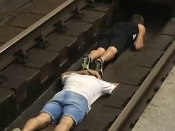 Hai thanh niên liều mình nhảy xuống đường ray chờ tàu đi qua